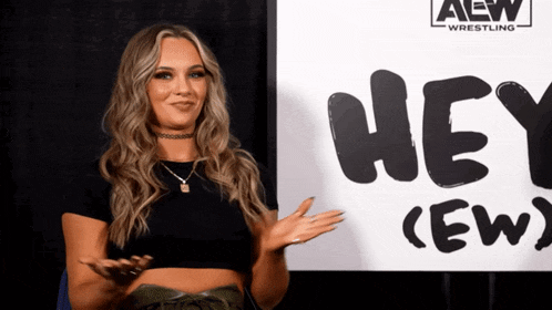 a woman is standing in front of a sign that says hey ( ew )