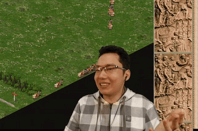 a man wearing glasses and a plaid shirt is smiling in front of a video game screen