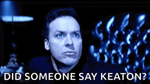 a man in a dark room with the words " did someone say keaton " below him