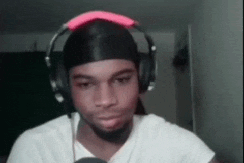 a young man wearing headphones and a headband is looking at the camera .