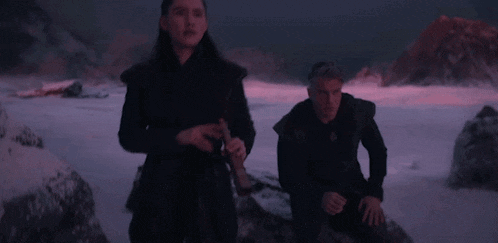 a man and a woman are holding hands in the snow .