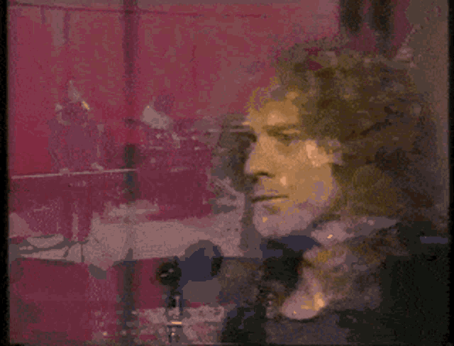 a man singing into a microphone with his mouth open