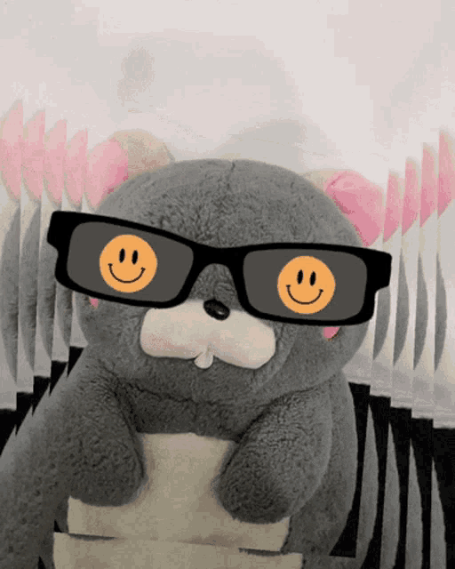 a stuffed animal wearing sunglasses and a smiley face on its eyes