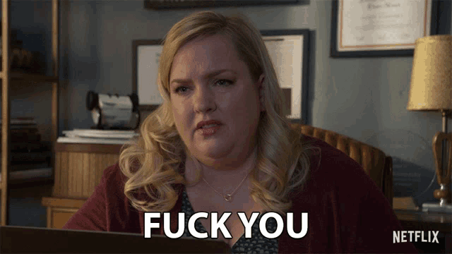 a woman sitting in front of a laptop with the words " fuck you " below her