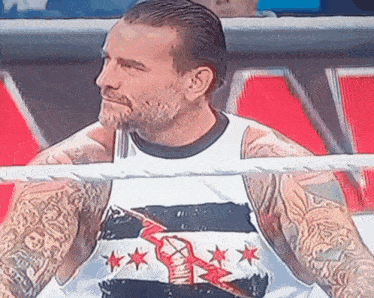 a man in a wrestling ring wearing a shirt that says ' cw ' on it