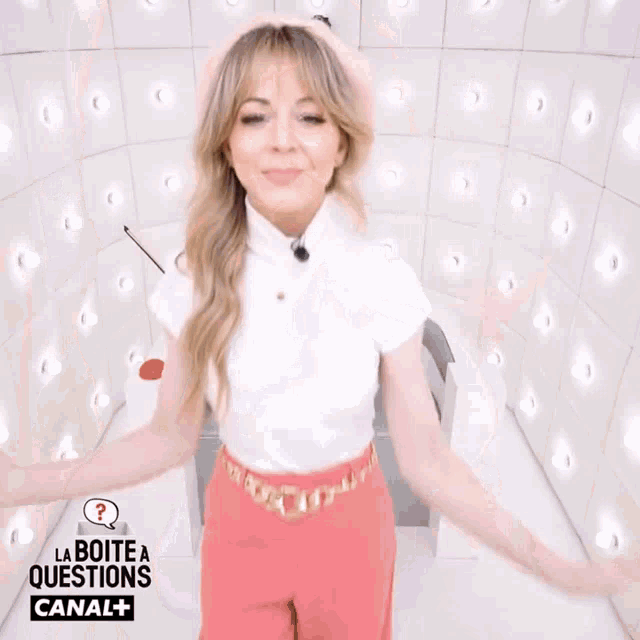 a woman is blowing a kiss in front of a sign that says la boite a questions canal+