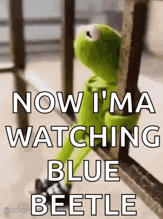 kermit the frog is sitting on a railing and watching a blue beetle on tv .