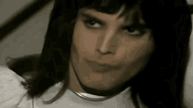 a close up of a man 's face with long hair .