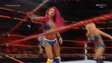 two women are wrestling in a ring and one of them is wearing a hula hoop .