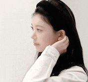 a woman wearing a headband is adjusting her hair .
