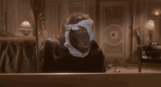 a monkey wearing a lace hat and collar is sitting on a bed .