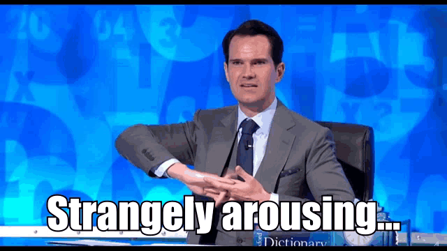 a man in a suit and tie is sitting at a desk with the words strangely arousing