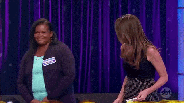 two women are standing on a stage and one of them has a name tag that says veronica