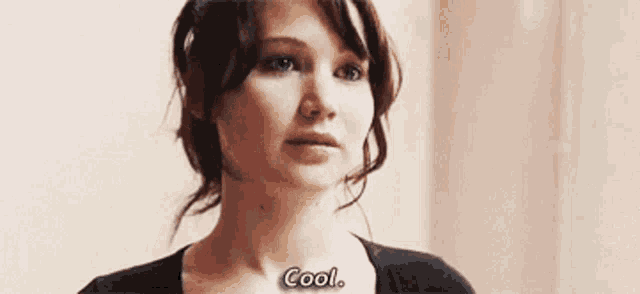 a close up of a woman 's face with the words `` cool '' written on her chest .