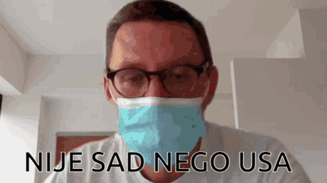 a man wearing glasses and a mask with the words nije sad nego usa written below him