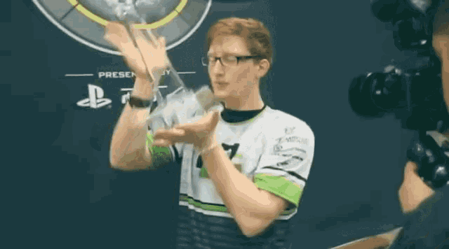 a man holding a trophy in front of a sign that says " present "
