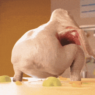 a statue of an elephant with its mouth open is standing on a table