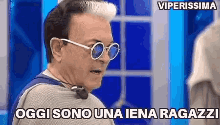 a man wearing sunglasses says " oggi sono una iena ragazzi " .