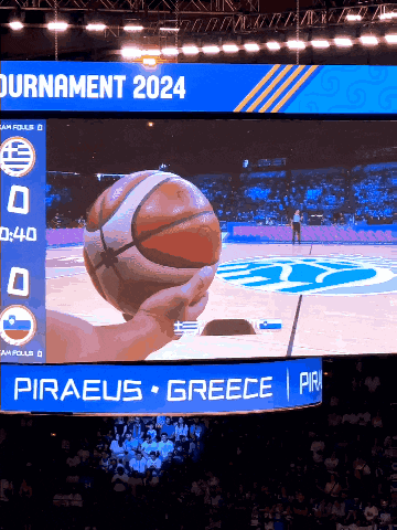 a large screen shows a basketball game between greece and pirates