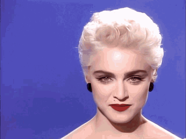 a close up of a woman 's face with blonde hair and red lips