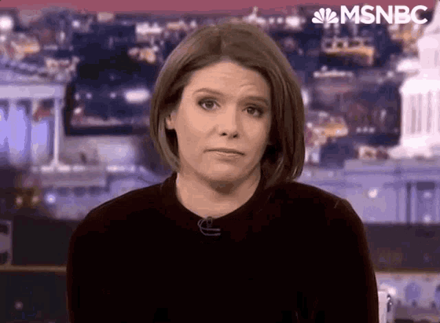 a woman is making a funny face while standing in front of a microphone on a television .