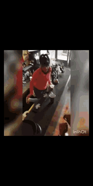 a man in a red shirt is standing on a bar