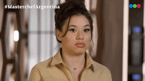 a woman is standing in front of a masterchef argentina sign