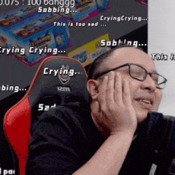 a man wearing glasses is sitting in a red and black chair with the words " crying crying sad " written on it