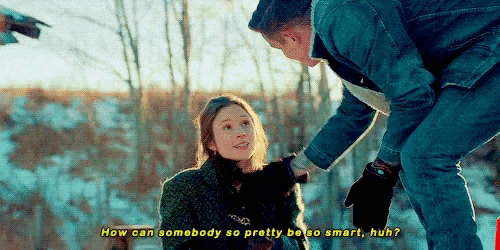 a man is kneeling down next to a woman and asking her how can somebody so pretty be so smart