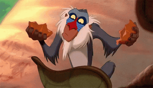a monkey from the lion king is sitting on a leaf and holding rocks .
