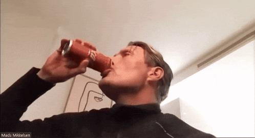 a man drinking from a red can with the name mads on the bottom right