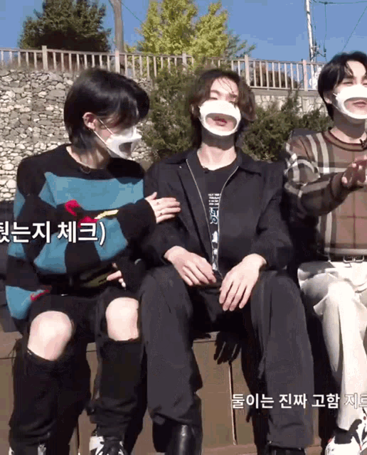 a group of young men wearing face masks and sweaters