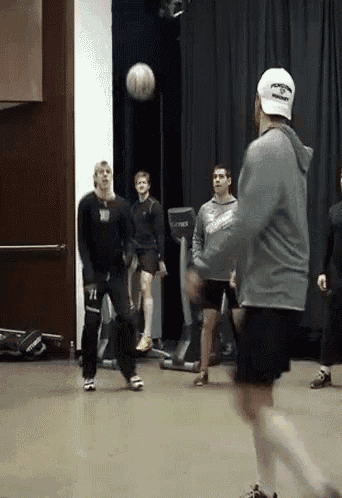 a man wearing a hat that says recovery is throwing a soccer ball