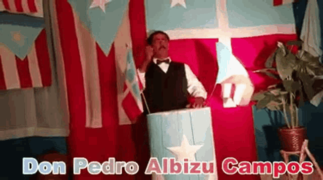 a man stands behind a podium with the name don pedro albizu campos written on the bottom