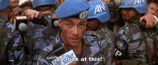 a man wearing a blue beret with an on it says so look at this
