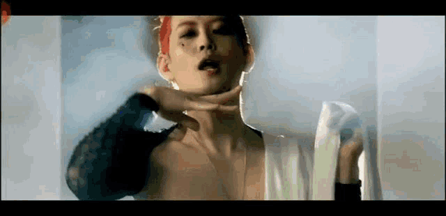 a woman with red hair is making a face with her hands while wearing a white dress .