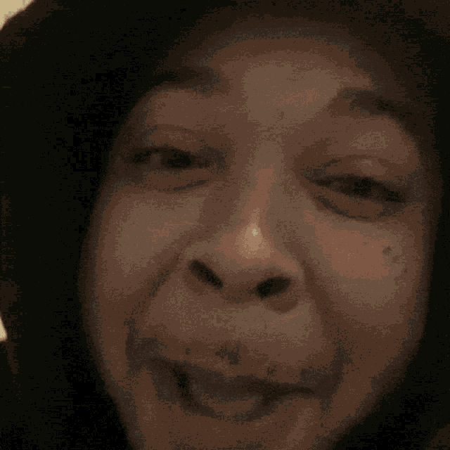 a close up of a person 's face with a black hoodie on