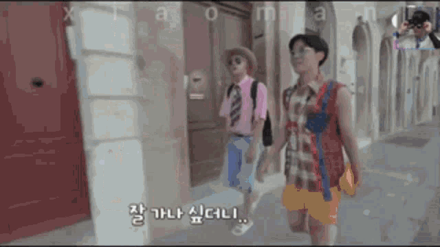 a couple of people walking down a street with chinese writing on the bottom