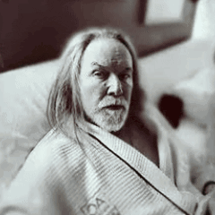 a man with long hair is wrapped in a blanket that says foster