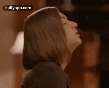 a woman is blowing smoke from her mouth .