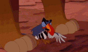 a cartoon of a bird with a red beak is standing next to a lion 's paws .