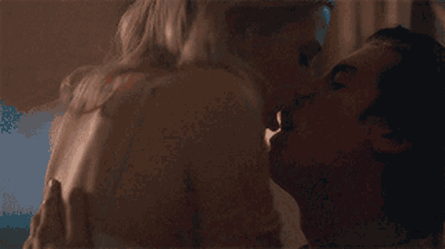 a man and a woman are kissing in bed