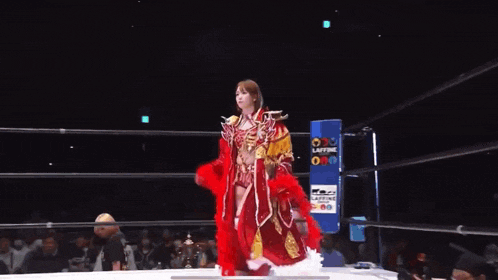 a woman in a red and gold outfit is standing in a wrestling ring with a sign that says caffeine on it