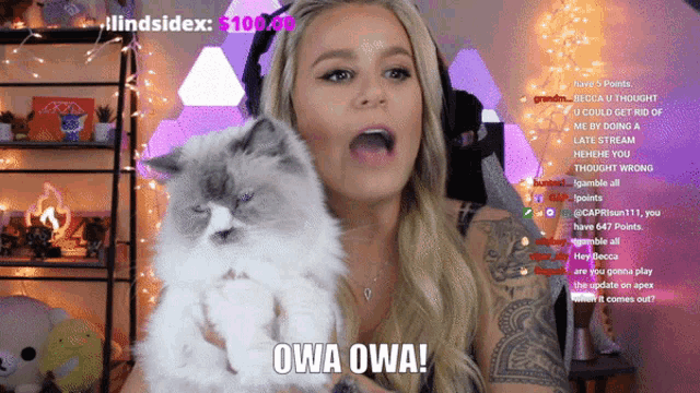 a woman holding a cat with owa owa written on the bottom