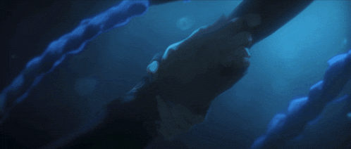a person is holding another person 's hand in the dark