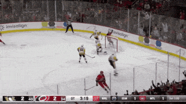a hockey game is being played with advertisements for invisalign in the background