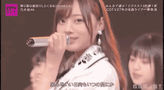 a girl is singing into a microphone with a cdtv logo in the corner