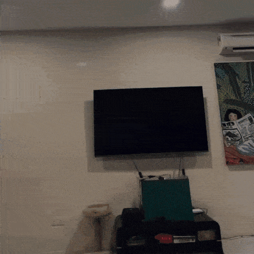 a painting of a woman reading a newspaper is above a flat screen tv