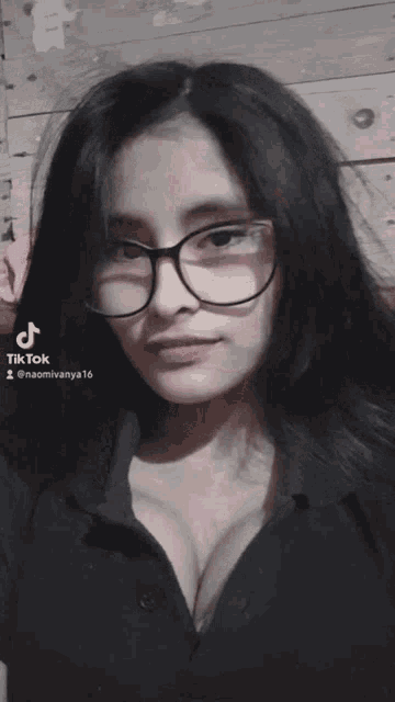 a woman wearing glasses and a black shirt has a tiktok icon on her face