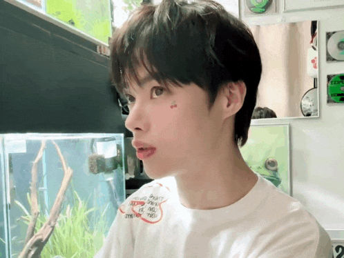 a boy with a cherry on his face is wearing a white shirt that says ' i love you ' on it